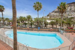 a swimming pool with palm trees and a resort at Villa Amanda in Playa del Cura