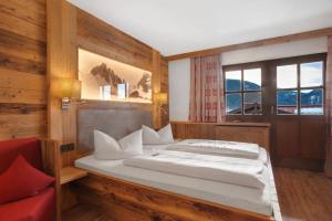 a bedroom with a bed and a red couch at Gästehaus Panorama - Appartement 3 in Reit im Winkl