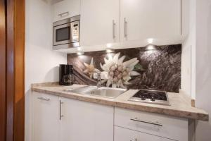 a kitchen with a sink and a microwave at Gästehaus Panorama - Appartement 3 in Reit im Winkl