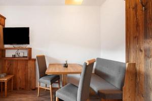 a dining room with a table and chairs and a tv at Gästehaus Panorama - Appartement 3 in Reit im Winkl
