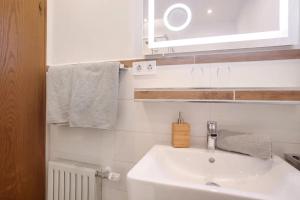 a bathroom with a sink and a mirror and towels at Gästehaus Panorama - Appartement 3 in Reit im Winkl +11 photos