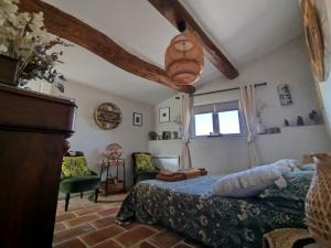 a bedroom with a bed and a couch and a window at Chambres D'hôtes La Buissonnière in Théziers