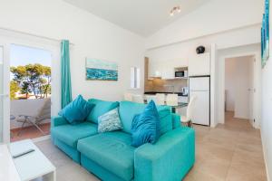 a living room with a blue couch and a kitchen at Trevol Suits in Cielo de Bonaire 