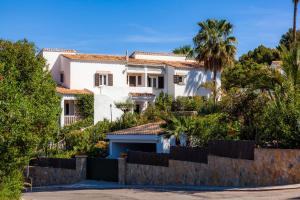 a white house with a fence and palm trees at Trevol Suits in Cielo de Bonaire 