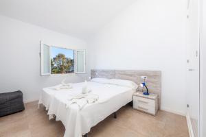 a white bedroom with two beds and a mirror at Trevol Suits in Cielo de Bonaire  +21 photos