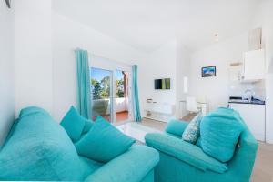 a living room with a blue couch and a window at Trevol Suits in Cielo de Bonaire 