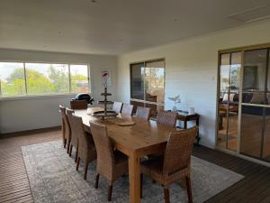 a dining room with a wooden table and chairs at Eunoia at Smiths in Smiths Beach