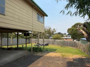 a house with a fence next to a yard at Eunoia at Smiths in Smiths Beach