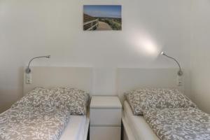 a bedroom with two beds and a picture on the wall at Apartment Habicht in Mühlbachl