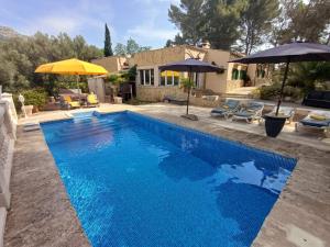a pool with umbrellas and a house at Casa Vista Monte in Llucmajor