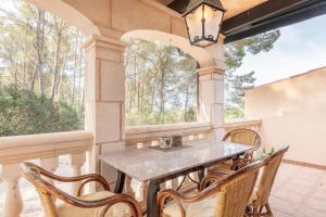 a table and chairs on a porch with windows at Casa Vista Monte in Llucmajor