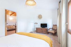 a bedroom with a bed and a tv and a living room at Casa Vista Monte in Llucmajor +27 photos
