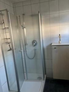 a shower with a glass door in a bathroom at Ferienwohnung Wartehof in Bad Emstal +3 photos