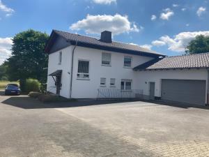 a white house with a driveway in front of it at Ferienwohnung Wartehof in Bad Emstal