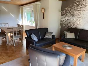 a living room with black leather furniture and a table at Ferienwohnung Wartehof in Bad Emstal