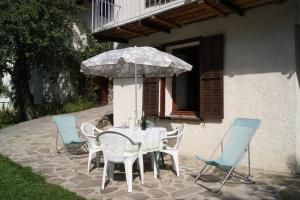 a table and chairs with an umbrella on a patio at Appartement La Petite Cascade in Allos