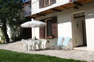 a patio with chairs and a table and an umbrella at Appartement La Petite Cascade in Allos