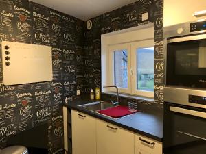 a kitchen with a sink and a microwave at Gîte Les Aubennes in Fromelennes +13 photos