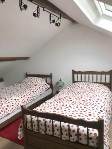 two beds sitting next to each other in a bedroom at Gîte Les Aubennes in Fromelennes