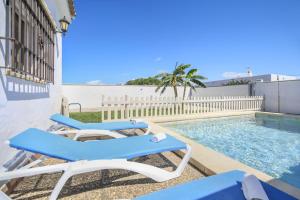 a patio with two lounge chairs and a swimming pool at Villa Ibicenca in Vejer de la Frontera