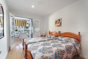 a bedroom with a bed with a floral bedspread at Apto Tomasol in Los Cristianos