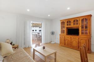 a living room with a couch and a tv at Apto Tomasol in Los Cristianos