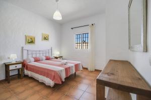 a bedroom with a bed and a table and a window at Villa Ibicenca in Vejer de la Frontera +16 photos