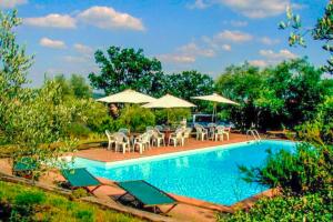 a swimming pool with chairs and tables and umbrellas at Casa Alta Villa esclusiva in Murlo