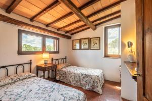 two beds in a room with two windows at Casa Alta Villa esclusiva in Murlo +37 photos