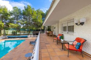 a patio with chairs and a swimming pool at Fidalsa Paradise Pines in La Alcayna