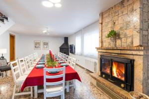 a dining room with a long table and a fireplace at Fidalsa Paradise Pines in La Alcayna