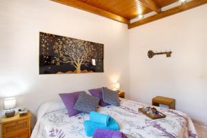 a bedroom with a bed with a tree painting on the wall at Vv Tasartico in San Nicolás +19 photos