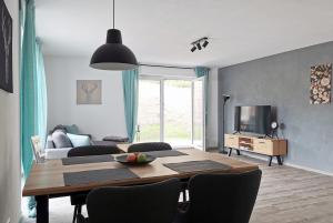 a living room with a dining room table and a television at Fuchsbau in Baiersbronn