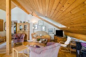 a living room filled with furniture and a wooden ceiling at Rose Garden in Heiligenberg