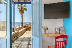a door to a room with a view of the ocean at La Casa Tinos 22 in Tinos