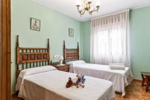a room with two beds with teddy bears sitting on them at Ca Carmina in Colunga