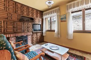 a living room with a fireplace and a tv at Ca Carmina in Colunga