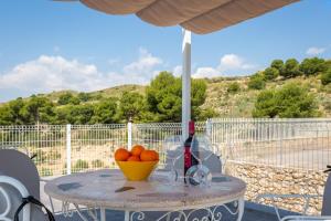 a table with a bowl of oranges and wine glasses at Fidalsa Imperial Malibu in Elche