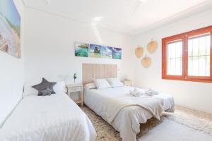 two beds in a room with white walls and windows at Fidalsa Imperial Malibu in Elche +25 photos