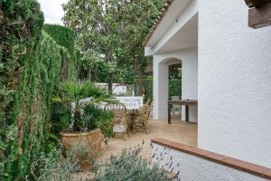 a patio with a table and chairs and plants at Villa la Barrufa in S'agaro