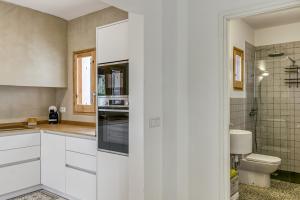a white kitchen with a sink and a toilet at Villa la Barrufa in S'agaro +29 photos