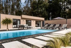a villa with a swimming pool and patio furniture at Casa D'avó Amália in Travanca