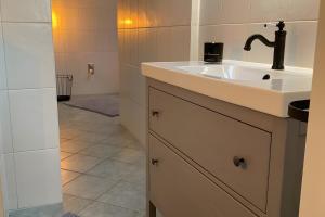 a white bathroom with a sink and a shower at Ferienhäuschen Gartenblick in Friedrichroda +12 photos