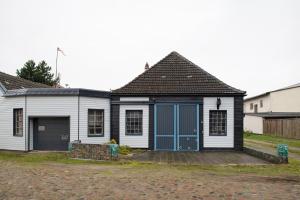 a small white house with a blue door at Studio zur »Alten Schmiede« in Laage +7 photos