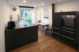 a kitchen with a large black cabinet and a table at Quartierblancdenoir Wohnungen in Reil