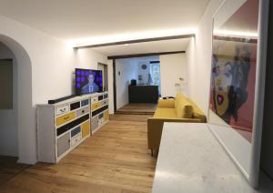 a living room with a yellow couch and a television at Quartierblancdenoir Wohnungen in Reil