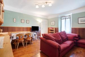 a living room with a red couch and a table at Residenza ai Noci in Lanzo dʼIntelvi
