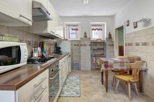 a kitchen with a table and a stove top oven at Residenza ai Noci in Lanzo dʼIntelvi