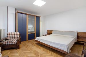 a bedroom with a bed and a chair at Residenza ai Noci in Lanzo dʼIntelvi