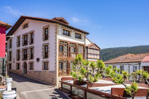 a view of a building with trees in front of it at Apartamentos El Rincón de Bustio in Bustio